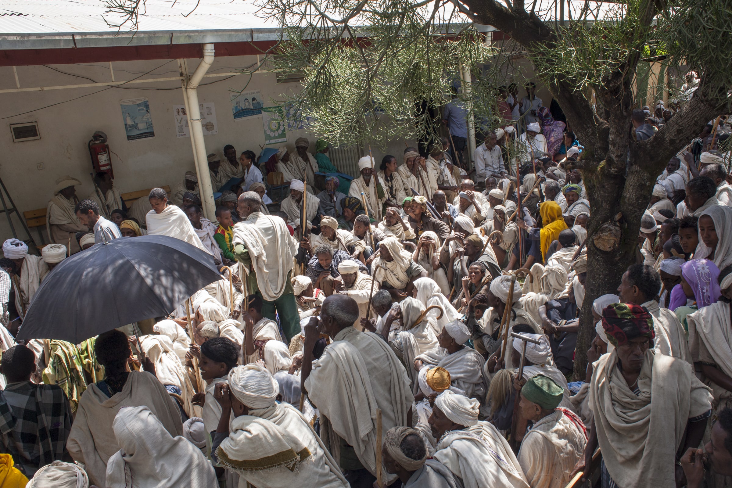 People sitting outside a hospital waiting for an eye test