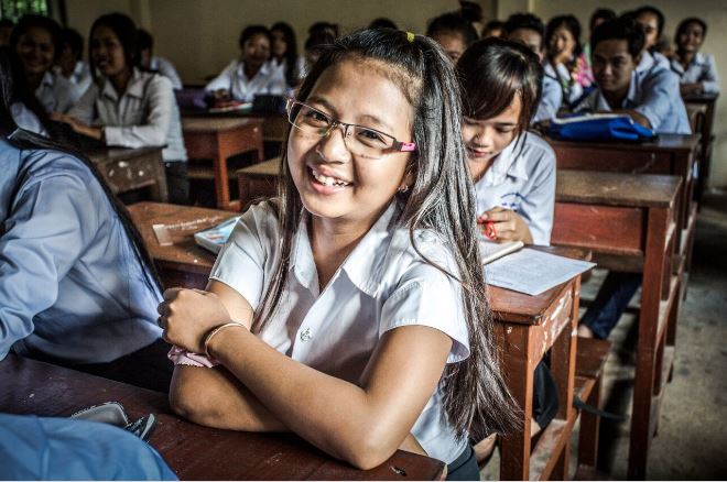 Une écolière souriant dans une salle de classe