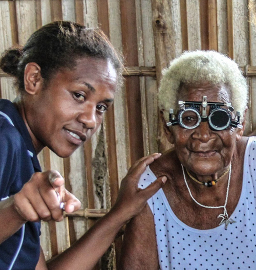 Nurse with an elderly lady doing an eye exam