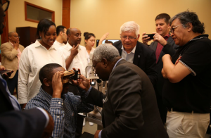 People look on as an eye care device use is demonstrated