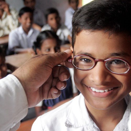 A man puts on a school boy's glasses