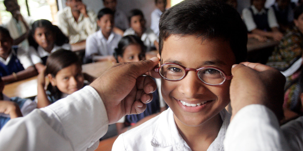 A man puts on a school boy's glasses