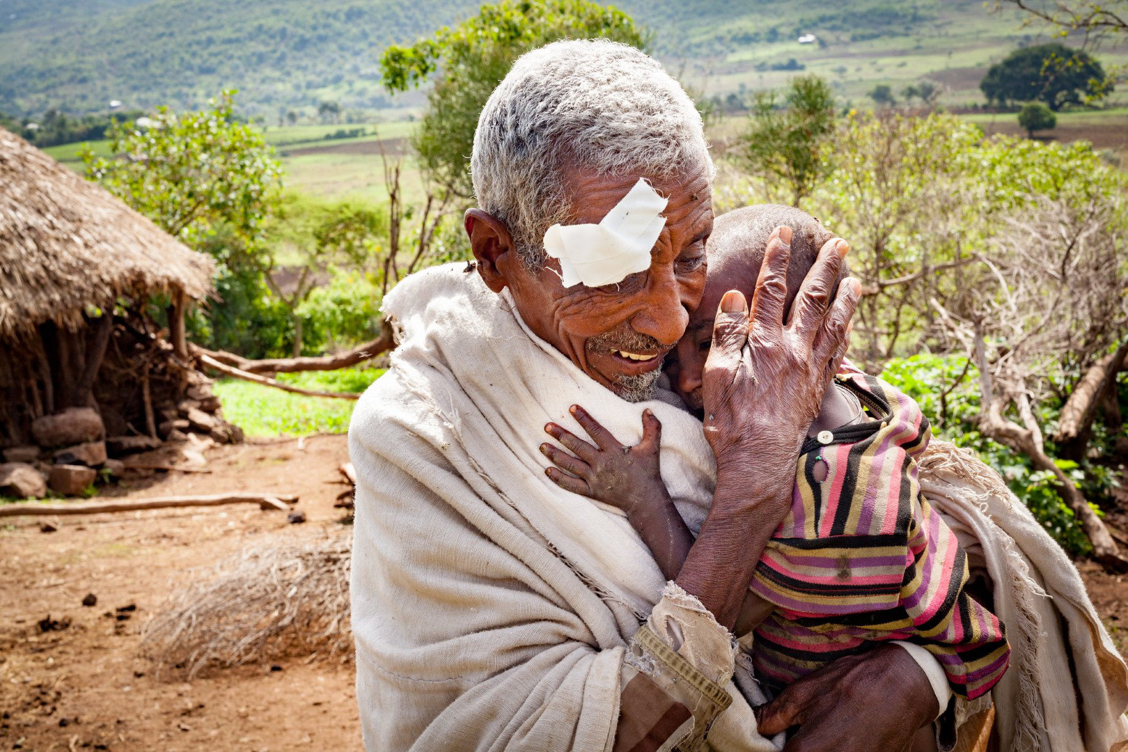 In their village in rural Burkina Fast, a grandfather and grandson embrace. The grandfather can see his grandchild clearly for the first time after his successful cataract surgery.