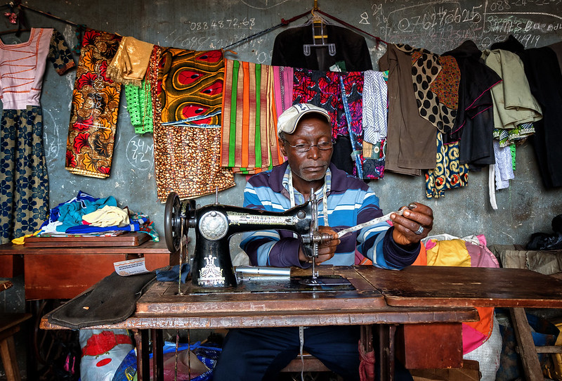 A tailor in Sierra Leona using his glasses to sew