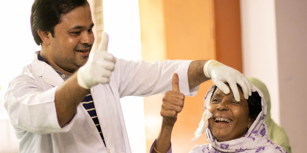 A lady smiles as her bandage is removed post cataract surgery