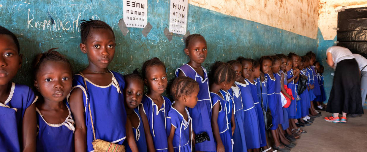 A class of school children await their turn to have their eyes examined at a school screening event in Sierra Leone
