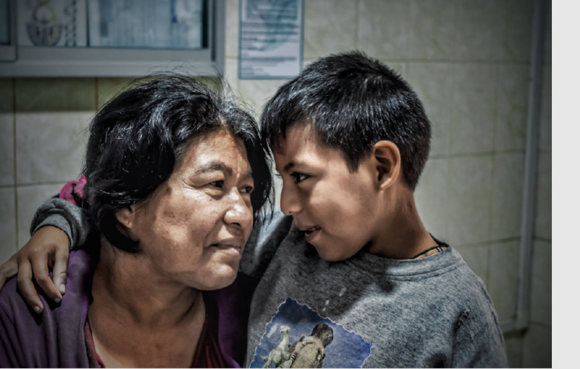 una madre que mira a su hijo por primera vez tras la operación de cataratas.