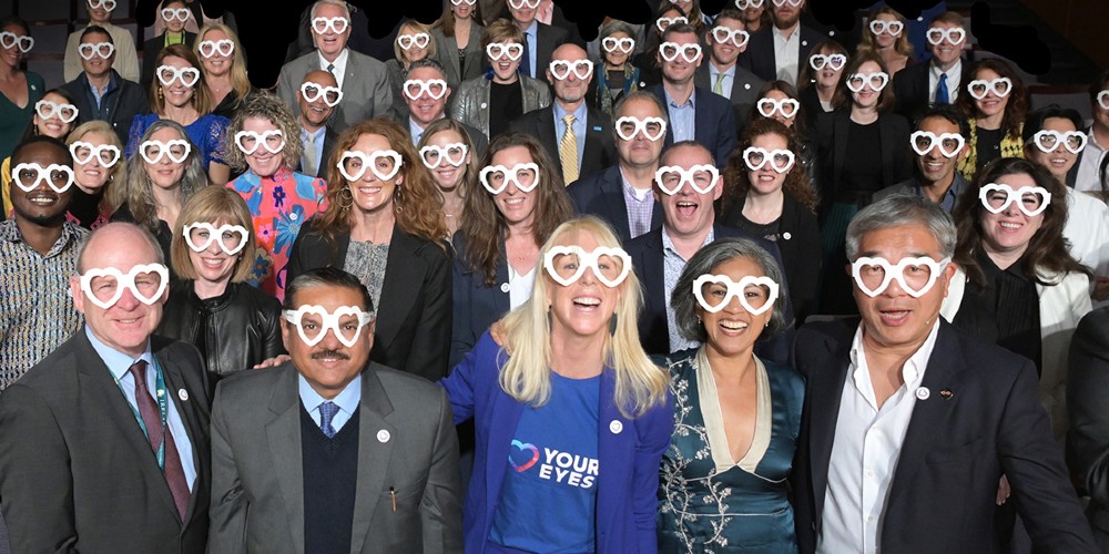 Un groupe de personnes posant avec des lunettes en plastique en forme de cœur sur les yeux à New York.