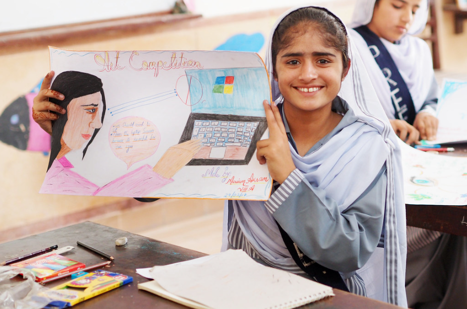 A girl in Pakistan holds an eye health awareness poster