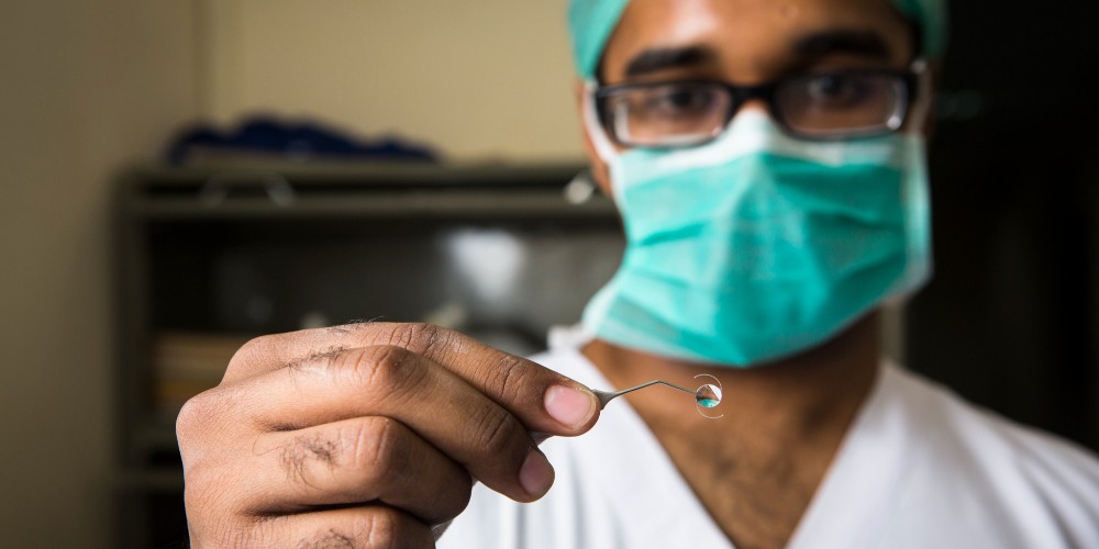 Un médico del Instituto Oftalmológico Venu de Nueva Delhi (India) muestra una LIO que se utiliza habitualmente en los procedimientos MSICS.