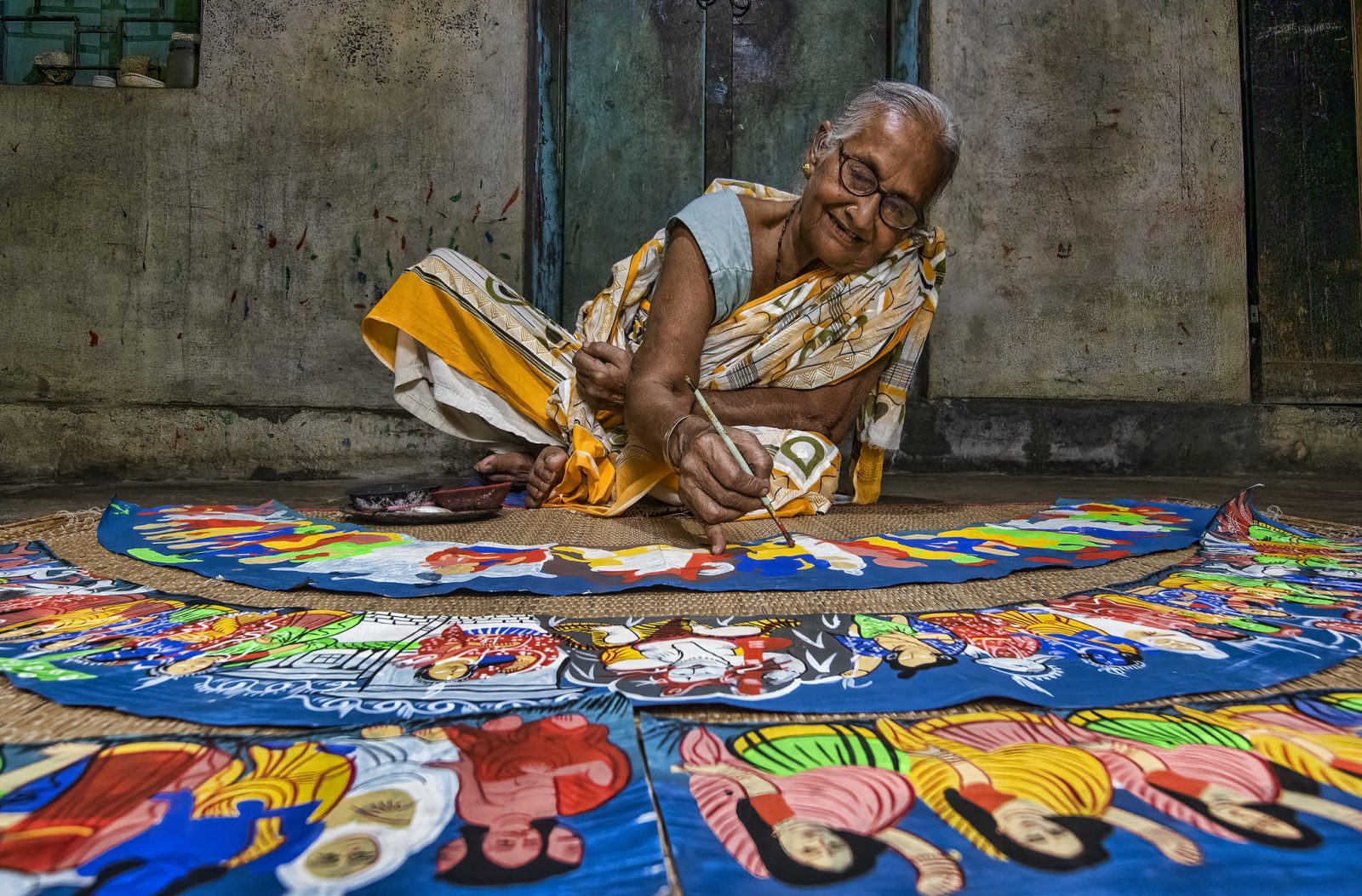 Elderly woman painting in Inde