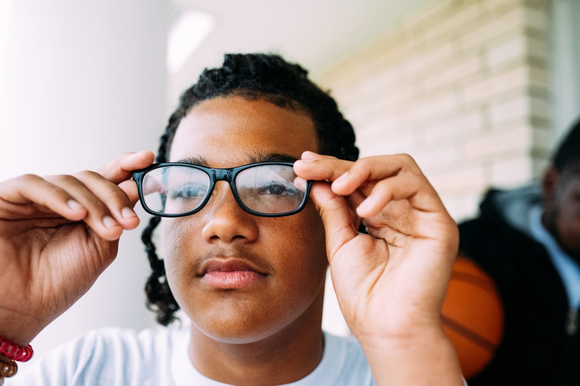 Vision Made Possible for 50 Million Children Worldwide - Josh putting glasses on his face