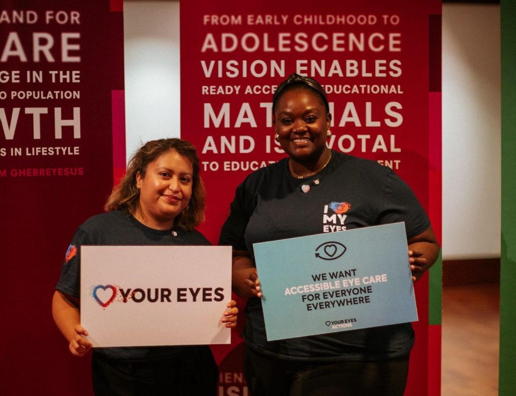 Two women holding eye health advocacy signs