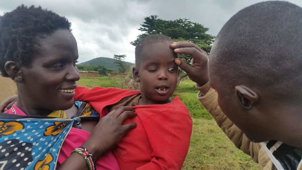 Photo credit: Ronald Kefa for the #StrongerTogether photo competition . A Trachomatous Trichiasis  (TT) Case finder examines a child's eyes in Kenya's Mara district.