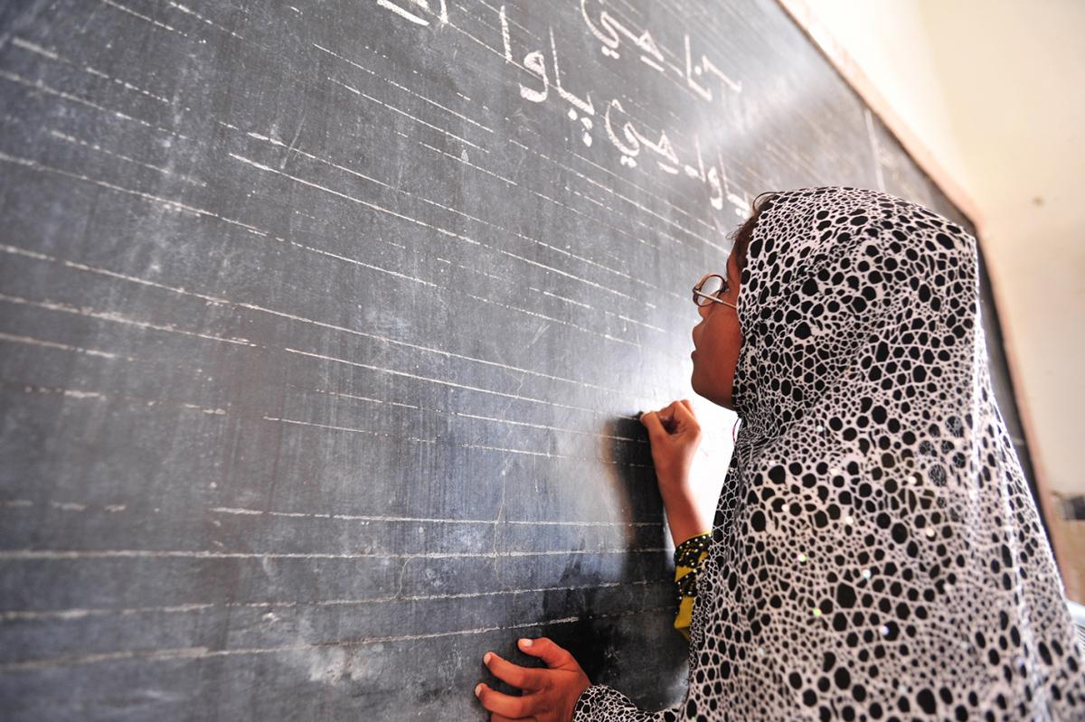 Child writing on the school blackboard