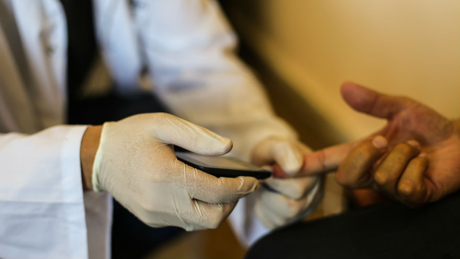 A man has his blood taken in his own bedroom as part of our RAAB study, August 2018