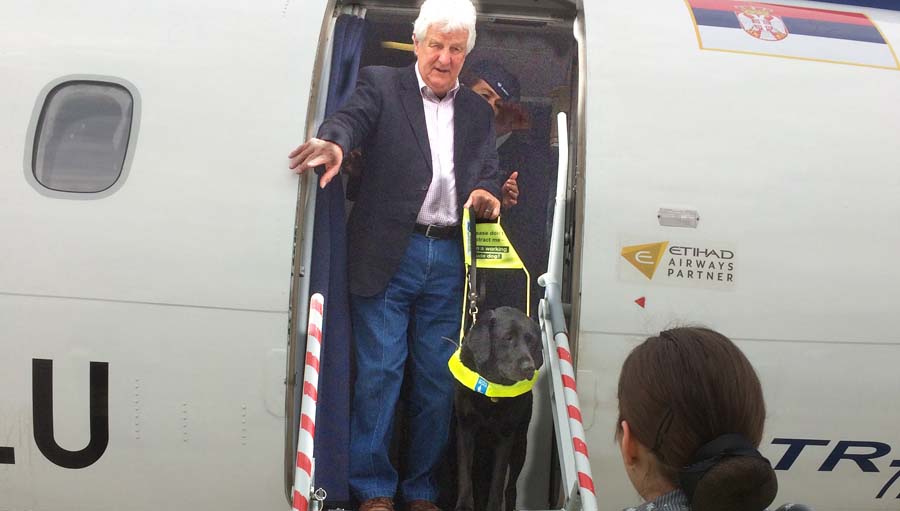 Promoting the Rights of Assistance Dog Users. David and Zoey getting off plane in Belgrade.