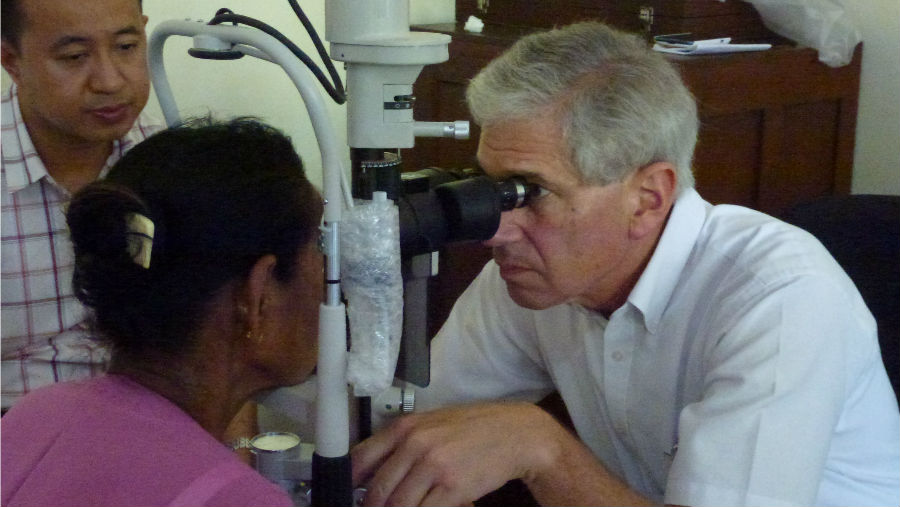 Story: Dr Cohn, recipient of AAO Humanitarian Service Award/ Image: Dr Cohn doing an eye exam