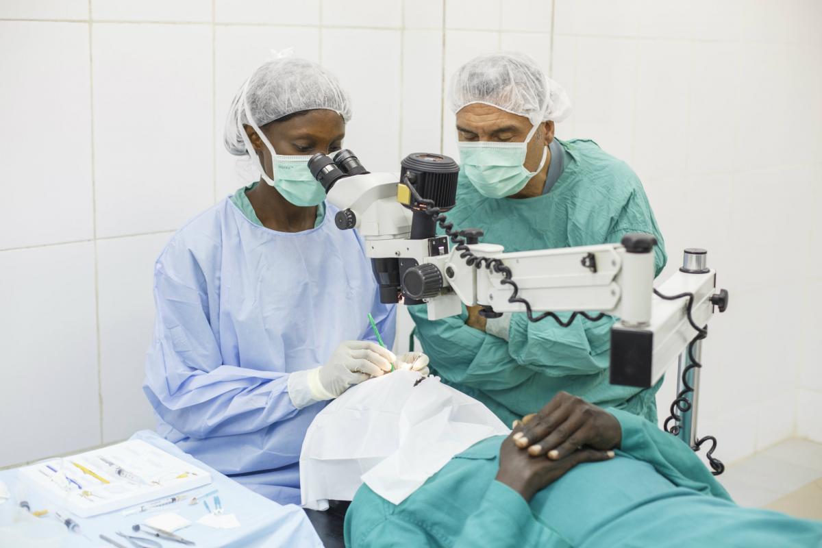 Dr Andre supervises a cataract surgeon in The Gambia