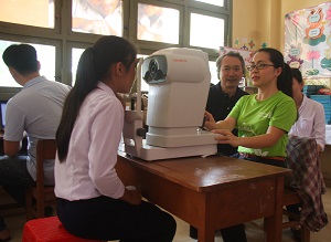 A Tien Giang hospital staff member demonstrates how to use the eye screening machine.