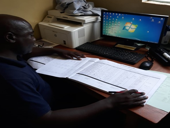 Mr Postan Phiri , Ophthalmic Nurse at Petauke Eye Clinic, aggregating data for monthly submission