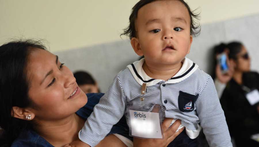 A child and mother; Orbis, Peru.