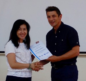 Thao, a participant, receiving a certificate from Karl Blanchett on completion of the course