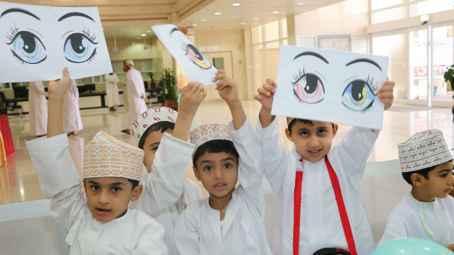 World Sight Day celebrations in Oman, children holding drawings of eyes