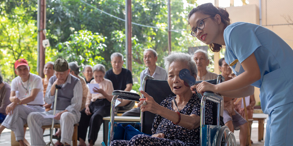 The refractionist is helping group of elders for visual check in Social protection center in Hanoi where the homeless elders are living.