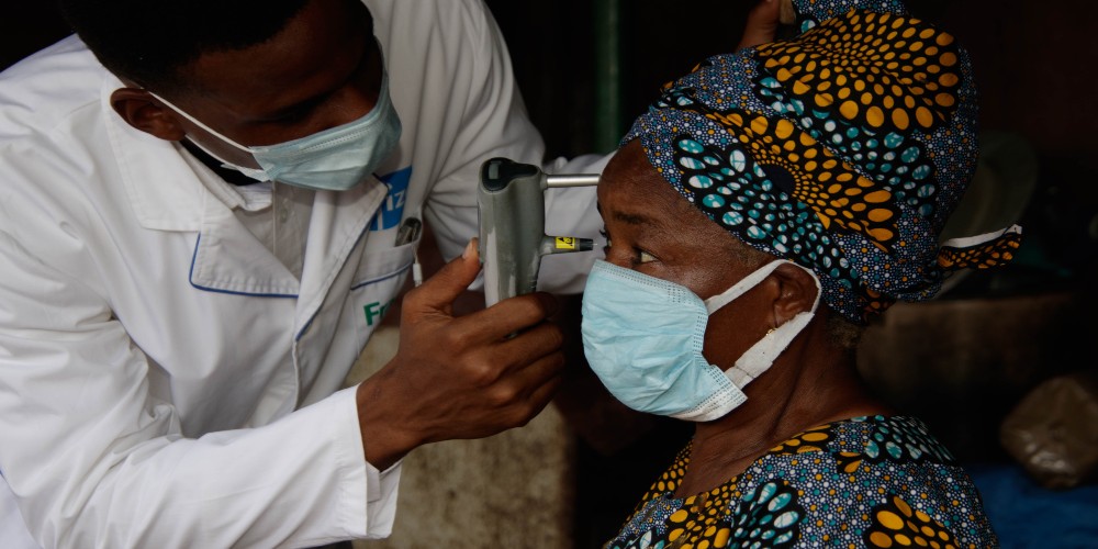 Dr Ezeh carrying out an intraocular pressure test on an elderly woman